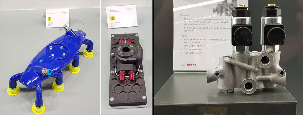 Kuvassa vasemmalla robotin tarttujia, jotka ovat yksi yleisimmistä 3D-tulostuskohteista tällä teollisuudenalalla. Oikealla hydraulikomponentti, joiden tulostus on yleistynyt, sillä painon vähentämisen lisäksi 3D-tulostus mahdollistaa kanavien optimoinnin. 